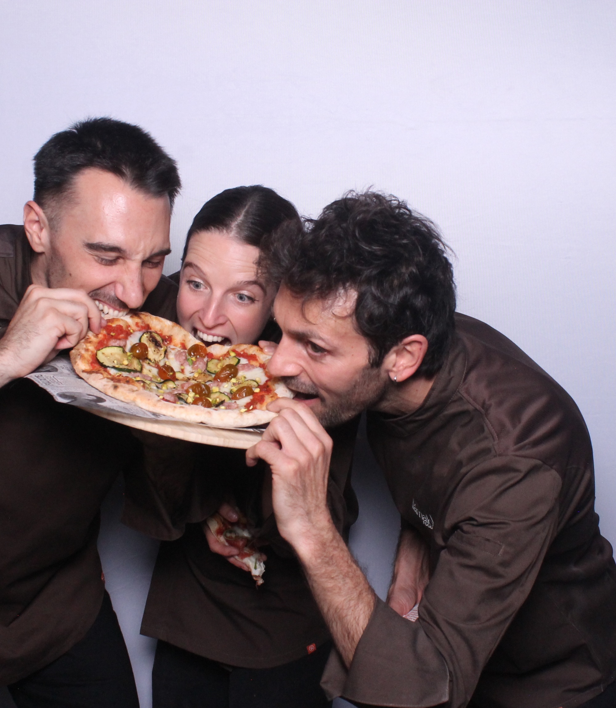 Equipo de llamalo x food comiendo pizza